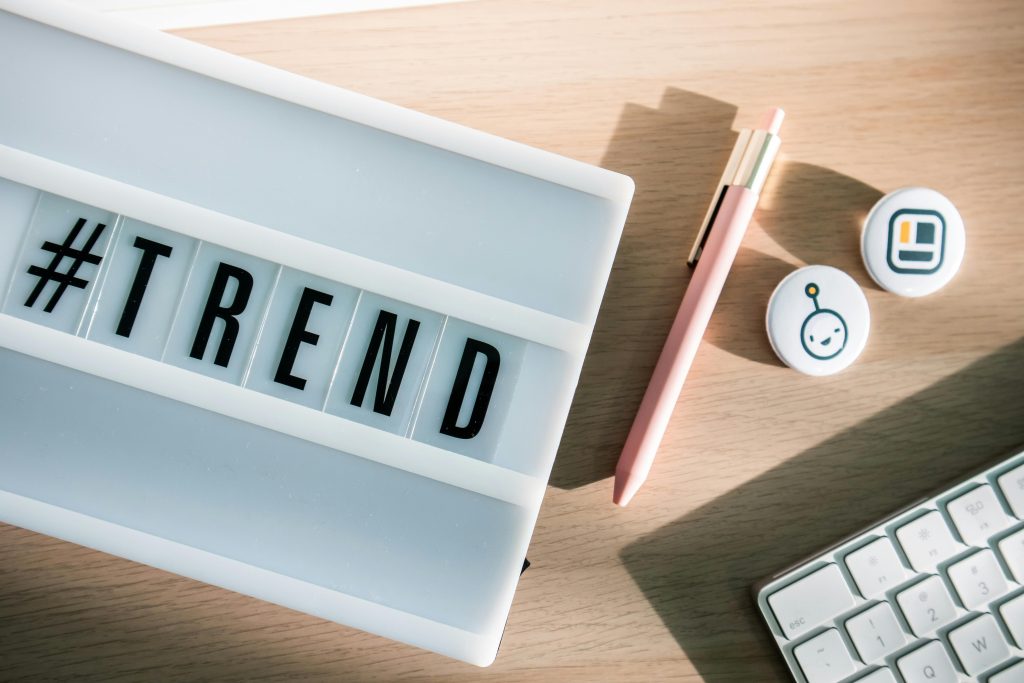 Stylish desk setup with a trendy lightbox, keyboard, and pink pen for modern office vibes.